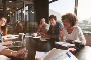 Group of people sitting around a conference room table