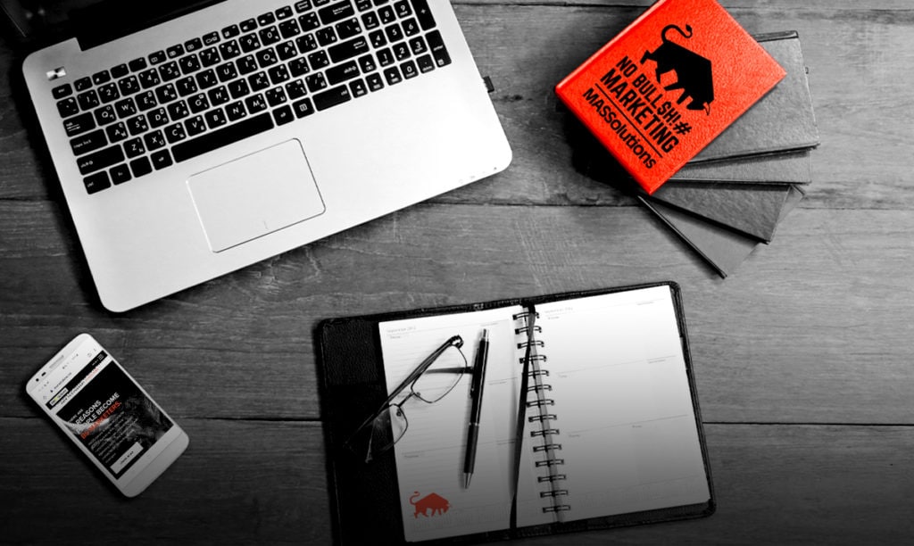 Flat lay image of a laptop, notebook, and cellphone with MASSolutions branding. Picture is used for a blog about empathy.