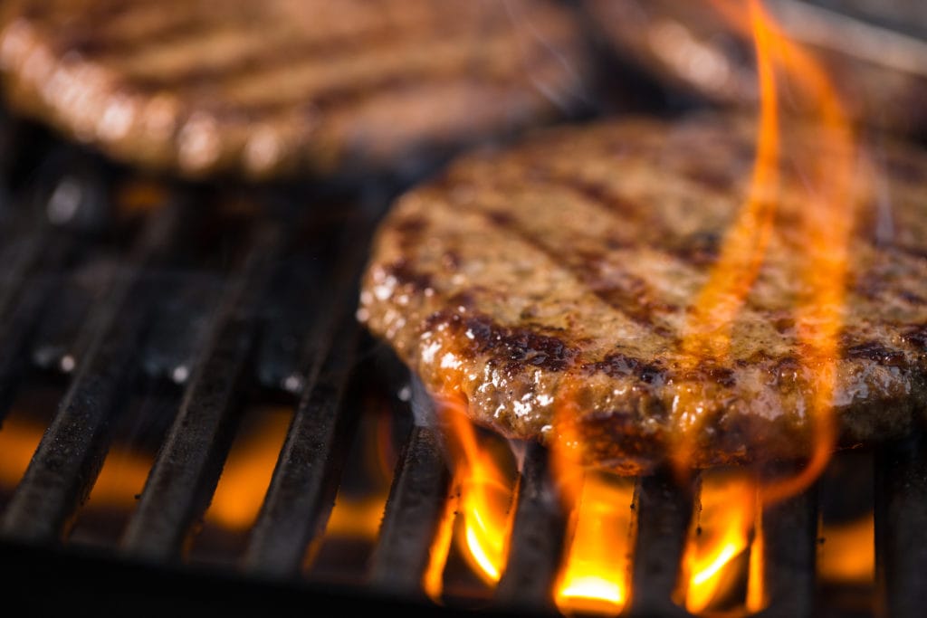 Picture of burger patties on an open flame for blog post about McDonald's